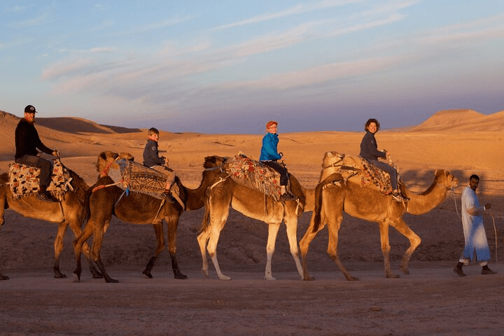 Family camel ride at golden hour in Agafay